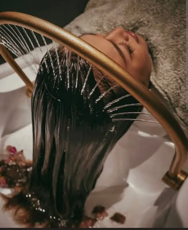 Long dark hair being rinsed at the basin